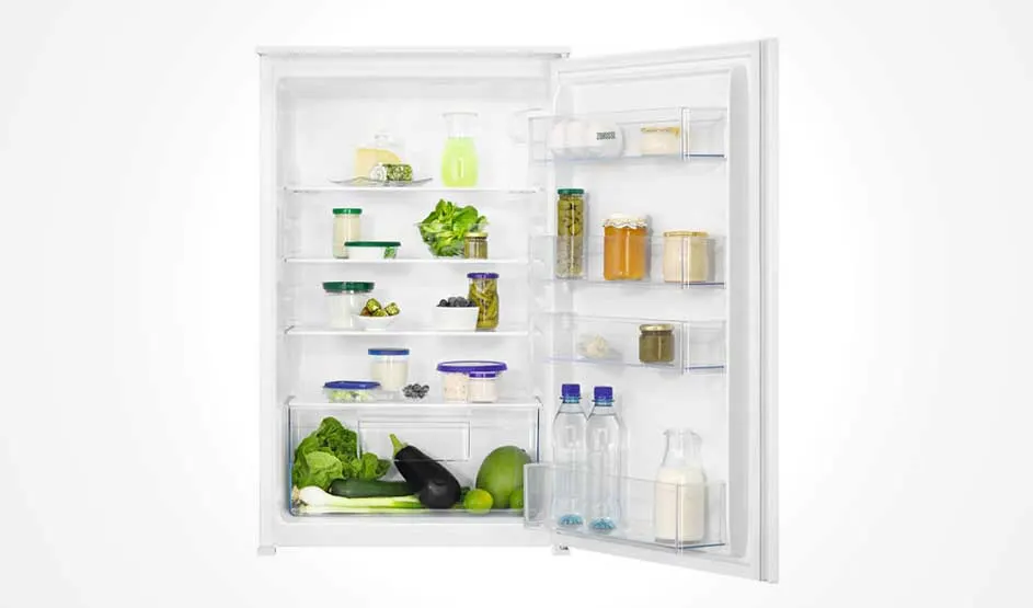 Un réfrigérateur blanc ouvert contient des aliments variés tels que des légumes, des fruits et des conserves sur plusieurs étagères.