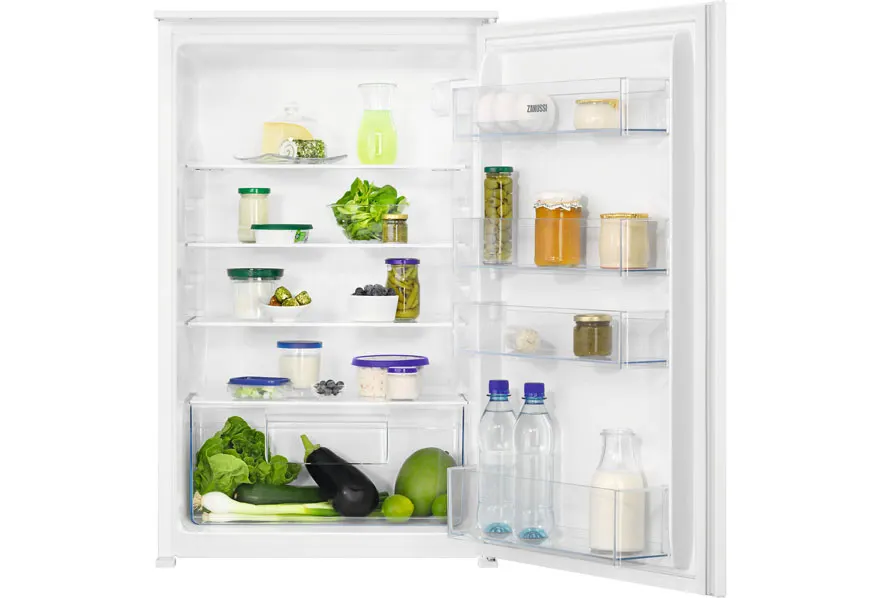 Un réfrigérateur blanc ouvert contient des aliments variés tels que des légumes, des fruits et des conserves sur plusieurs étagères.