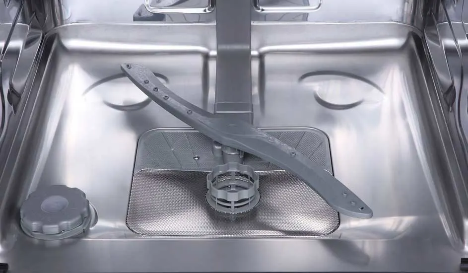 The inside of a clean, empty dishwasher with a metal filter and a grey spray arm. No brand is visible on the appliance.
