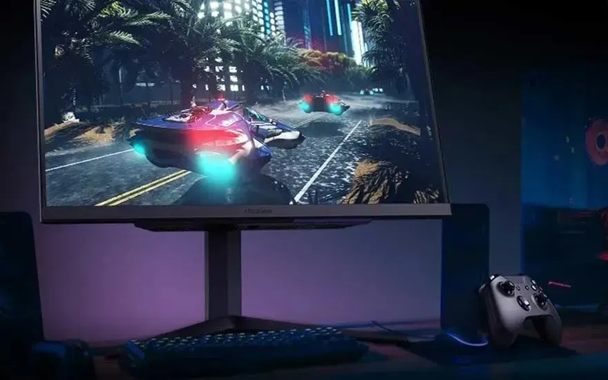 Gamingopstelling: monitor toont futuristische race met zwevende wagens in neonstad; op bureau staan toetsenbord en gamecontroller.