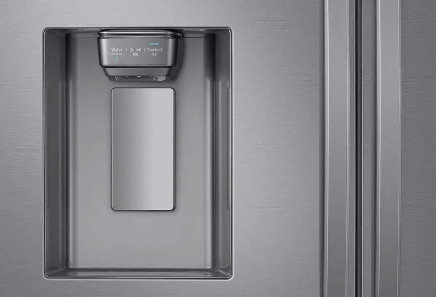 Een close-up van een metalen koelkast met een ingebouwde water- en ijsdispenser. De dispenser heeft knoppen voor water, ijsblokjes en gemalen ijs.