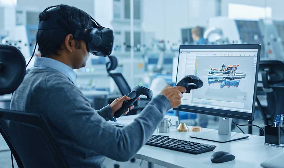 Un homme porte un casque de réalité virtuelle et manipule un modèle 3D avec deux manettes, affiché sur son écran d’ordinateur.