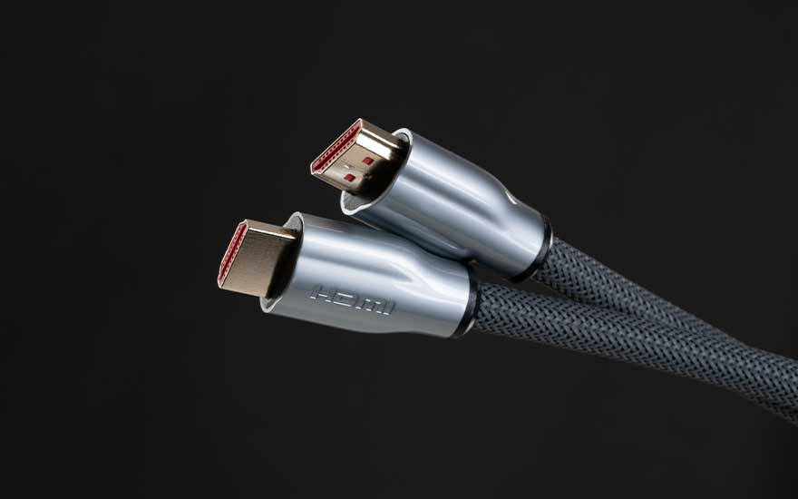 Deux connecteurs HDMI avec gaine tressée apparaissent en gros plan sur fond noir, dans un style sobre et moderne.