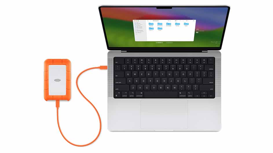 Een open laptop met een oranje externe harde schijf aangesloten via een kabel, tegen een witte achtergrond.