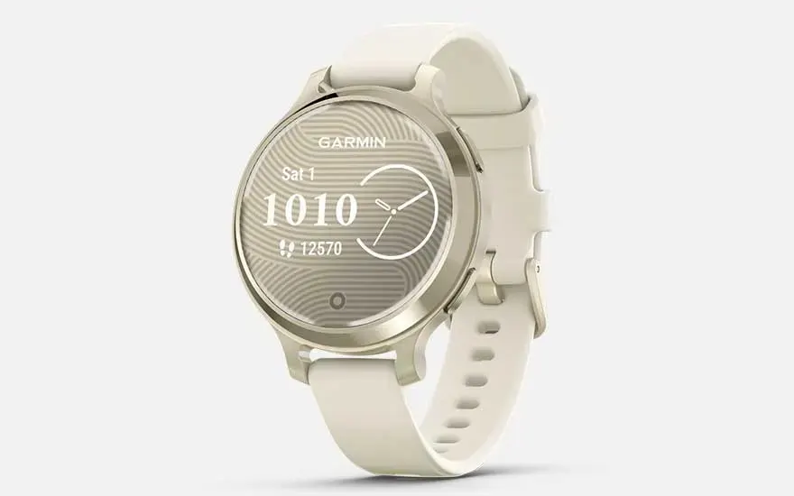 Een stijlvolle, beige Garmin smartwatch toont tijd, datum, digitale klok, stappen en een analoge wijzerplaat op een licht golvend scherm.