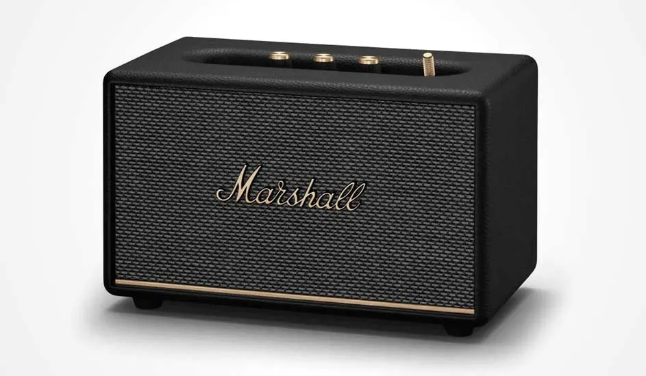 Voici une enceinte Bluetooth Marshall noire au design rétro, avec des boutons dorés et le logo Marshall sur le devant.