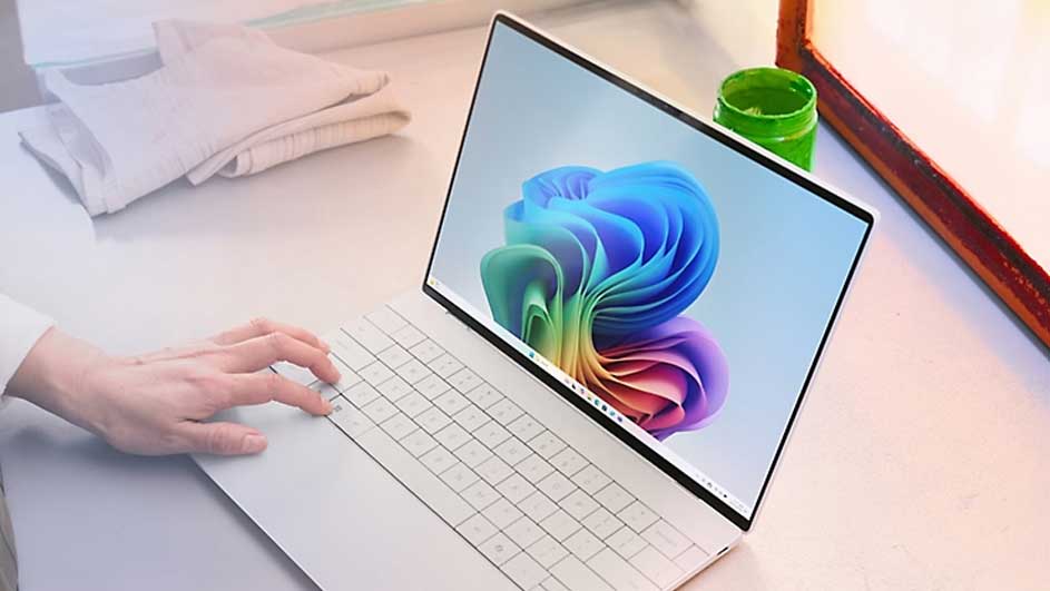 Hand gebruikt een witte laptop met Windows 11-scherm op een lichte werkplek.