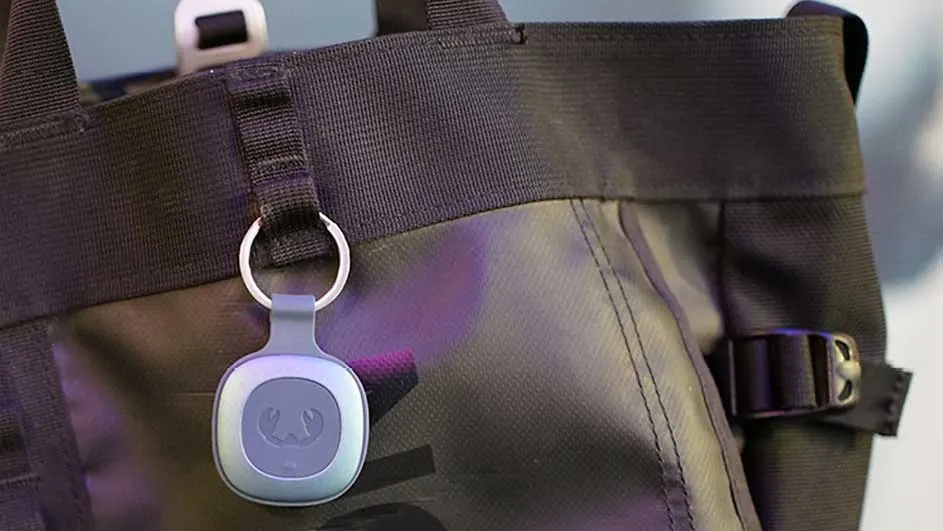 Zwarte draagtas met grijze sleutelhanger eraan bevestigd. De sleutelhanger heeft een ring en een kreeftafbeelding.