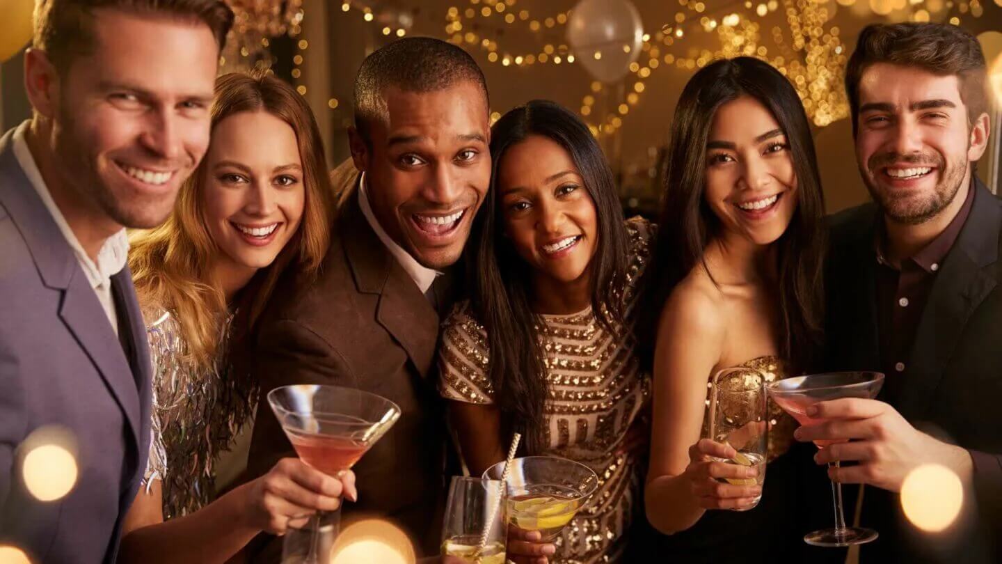 Fête illuminée avec cocktails. Décor doré scintillant en arrière-plan.