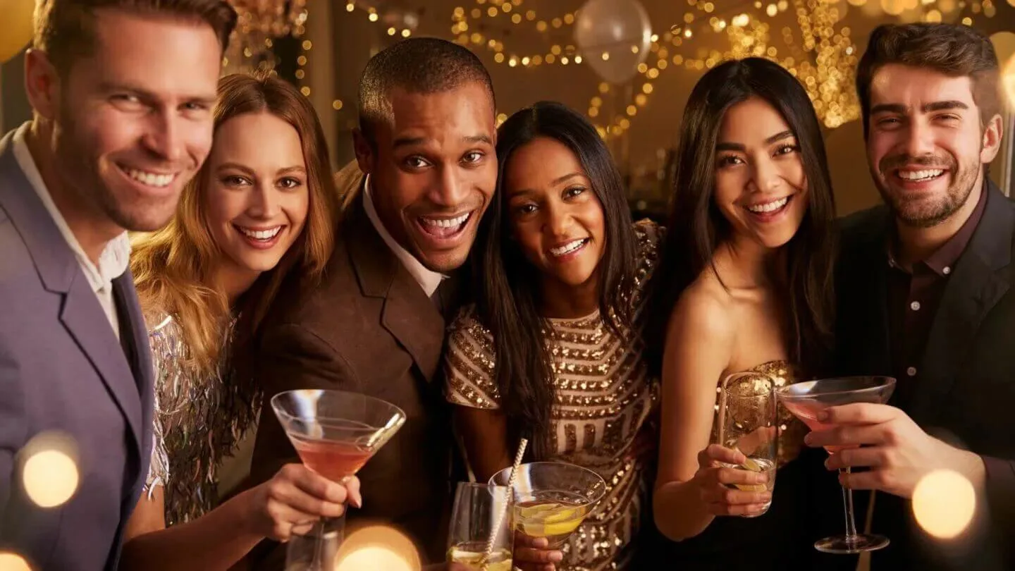 Fête illuminée avec cocktails. Décor doré scintillant en arrière-plan.