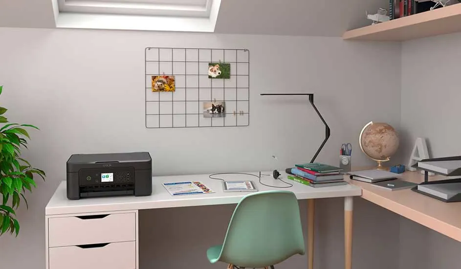 Bureau blanc avec imprimante noire, lampe, chaise verte et étagère murale dans une pièce lumineuse.