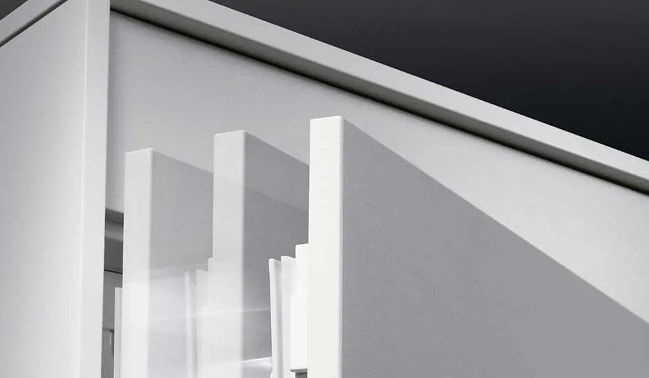 Gros plan sur des panneaux blancs structurés avec des lignes géométriques et des jeux d'ombre, sur fond sombre.