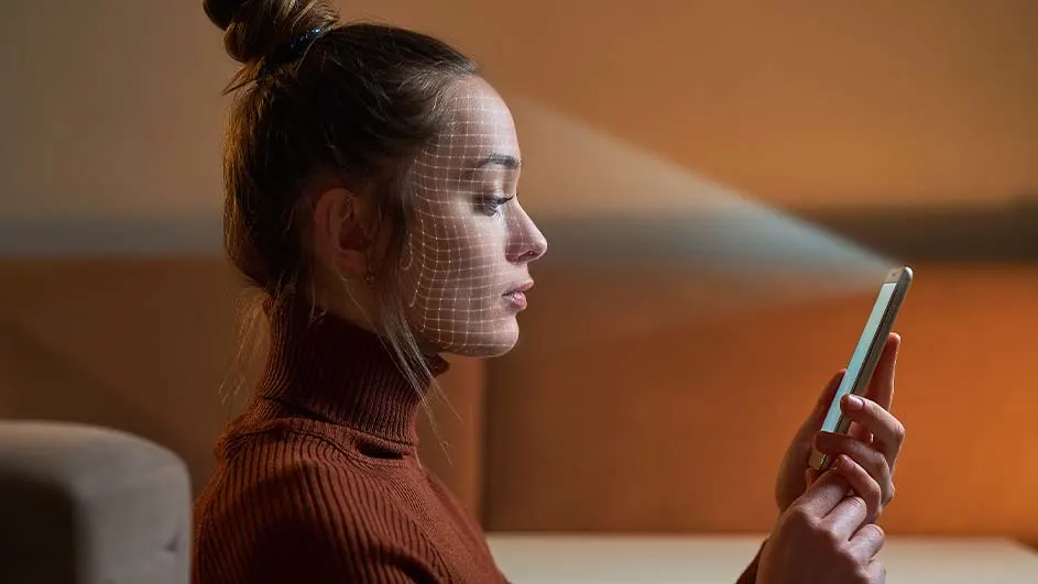 Een gsm scant een gezicht met behulp van een raster. De achtergrond is warm bruin.