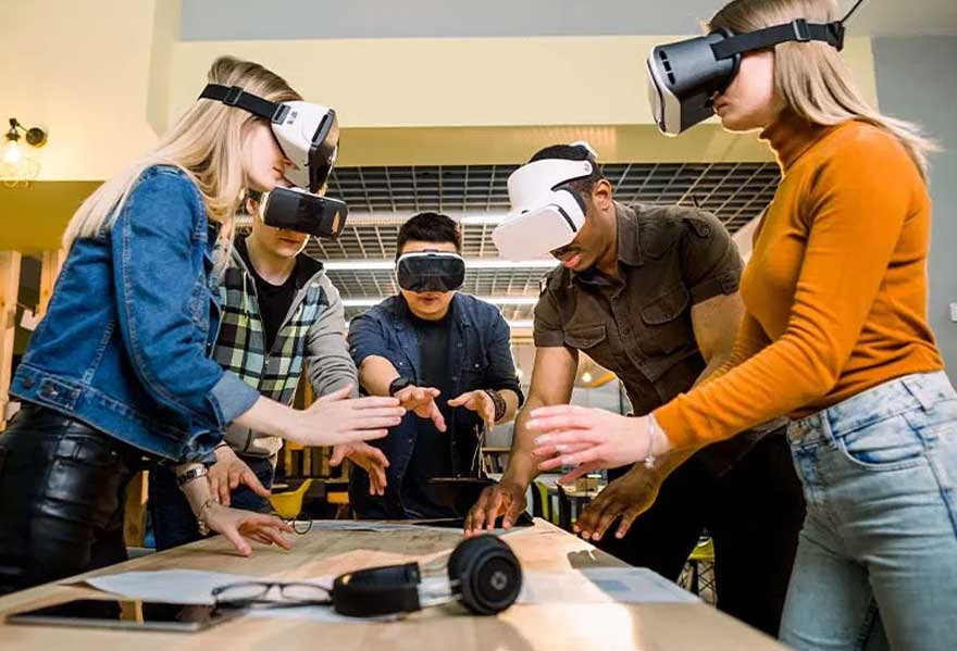 Un groupe utilise des casques VR autour d'une table avec des lunettes, un haut-parleur et une tablette.