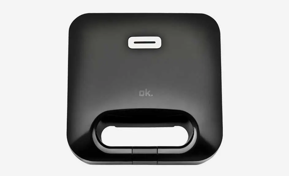 Vue de dessus d'un appareil noir de marque "ok." avec poignée et indicateur lumineux sur fond blanc.