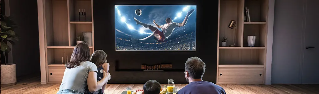 Une télévision affiche un match de football dans un salon. Des étagères en bois sont de chaque côté de la télévision.