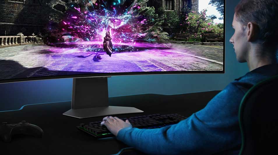 Een gebogen monitor toont een videospel met paarse effecten. Een toetsenbord en controller liggen op het bureau eronder.