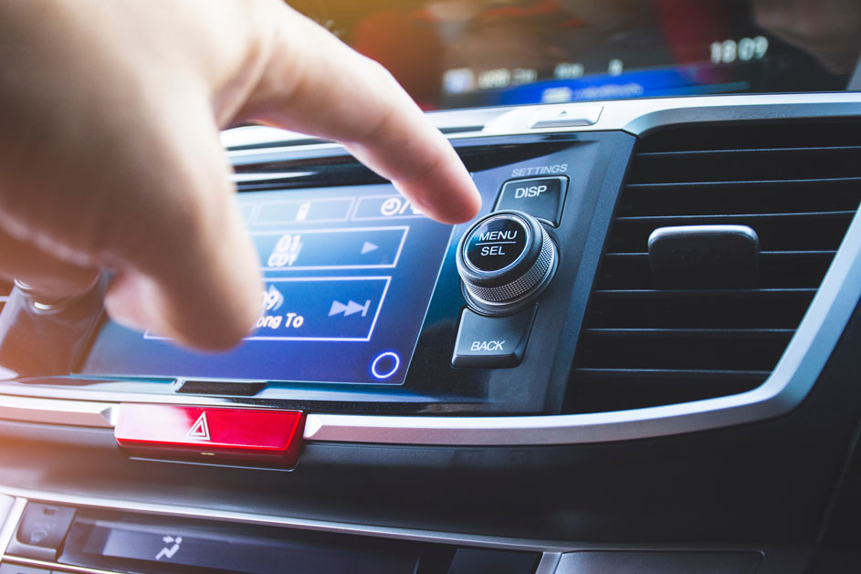 Een vinger drukt op het blauwe autoscherm naast een draaiknop met "MENU SEL", boven een "BACK"-knop.