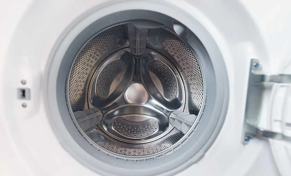 Een openstaande witte wasmachine met een zilverkleurige, geperforeerde trommel en drie roerwerken.