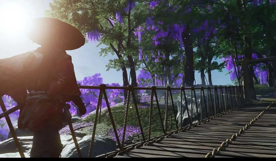 Ceci est un jeu vidéo. Un samouraï traverse un pont en bois, entouré de fleurs violettes et de lumière du soleil parmi les arbres verts.
