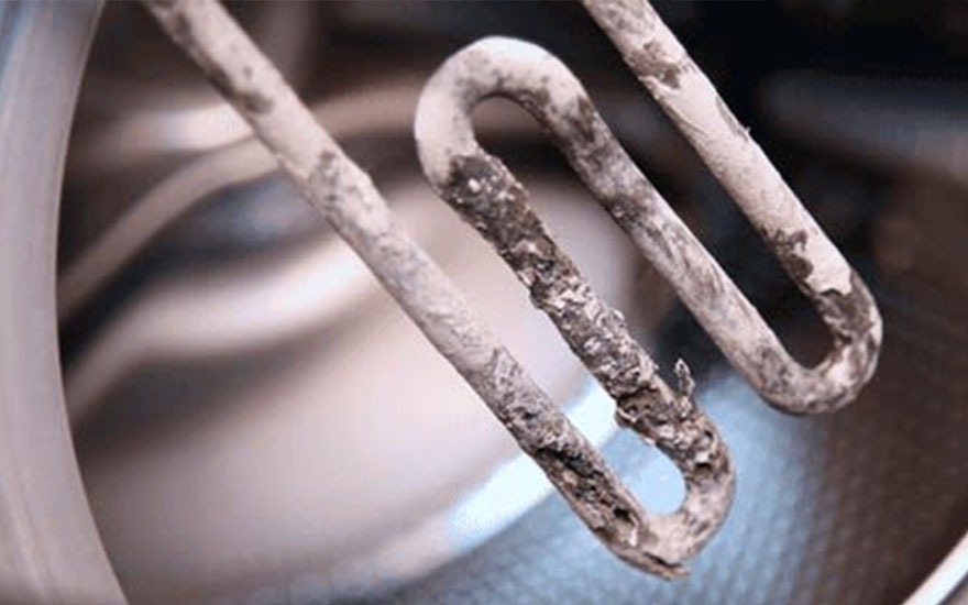 Serpentin rouillé et usé dans un lave-vaisselle. Dépôts minéraux visibles.