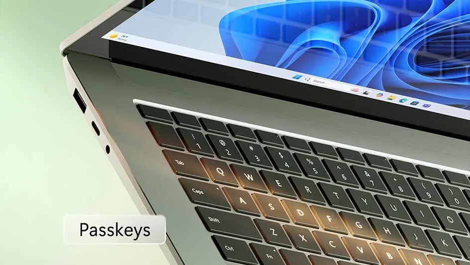 Laptop schuin van voren, met zwart toetsenbord en Windows-achtergrond. Poorten zichtbaar aan de zijkant. 'Passkeys' tekstlabel.