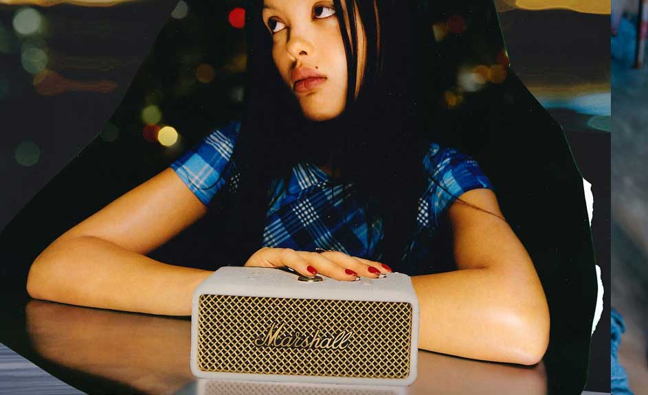 Een witte Marshall-luidspreker op een tafel met een gouden rooster. Op de achtergrond is een donkere en vage achtergrond.