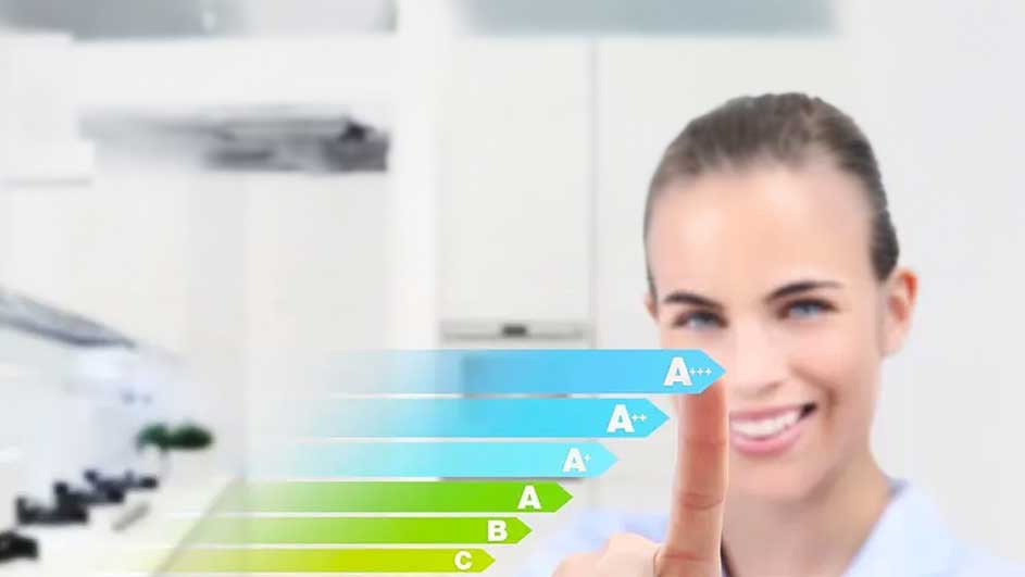 Dans une cuisine claire, un tableau de classement énergétique coloré pointe les lettres A à C.