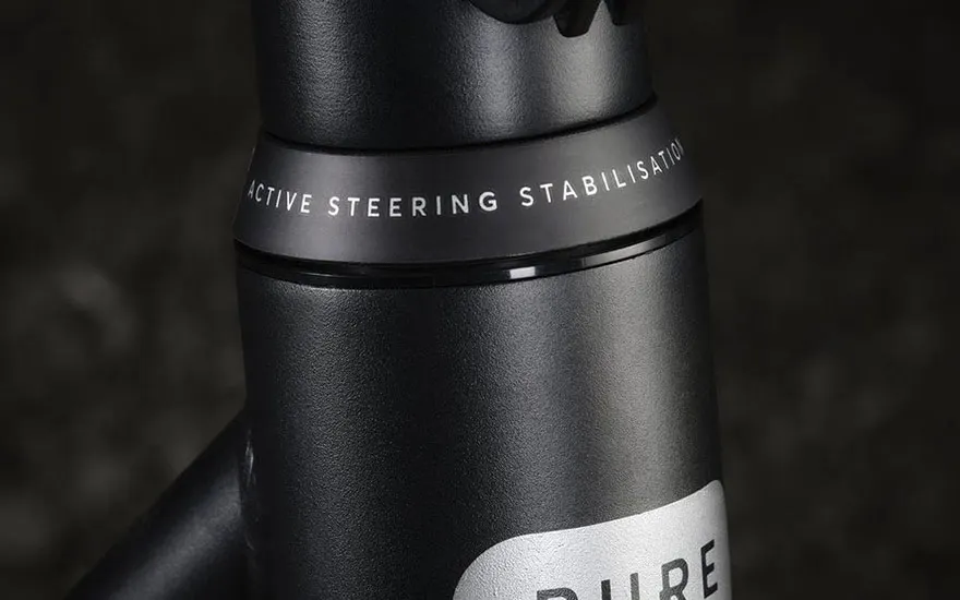 Detail van een zwarte stuurkolom met opschrift “active steering stabilisation”, die de stabiele besturing van de e step benadrukt.