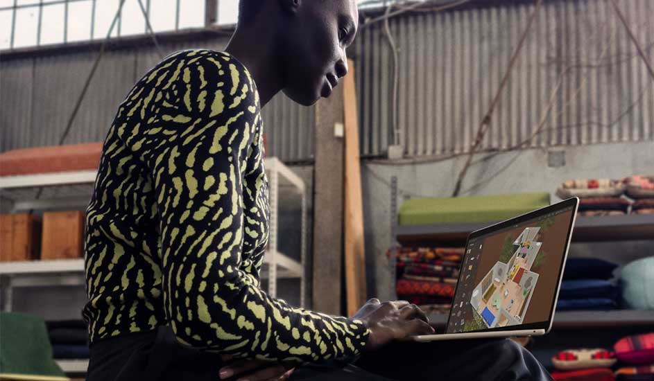 Een laptop toont een plattegrond tegen een achtergrond van opgeslagen goederen in een magazijnachtige ruimte.