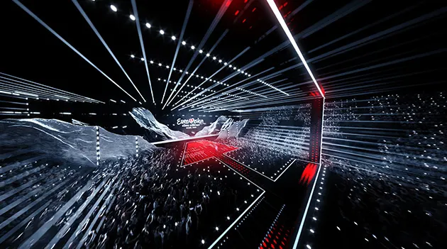 Une scène de l'Eurovision éclairée des lumières rouges et blanches sur fond noir.