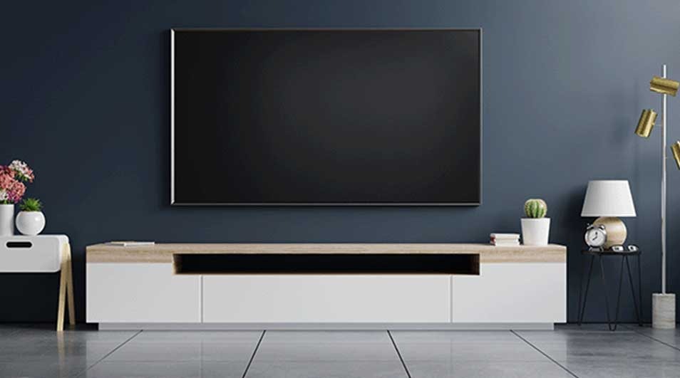 A living room with a large black television on a blue wall above a white and wood media center.