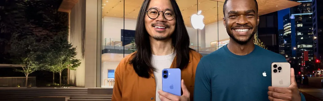 Two people hold smartphones in front of an Apple store at night. There are trees, stairs and city buildings in the background.