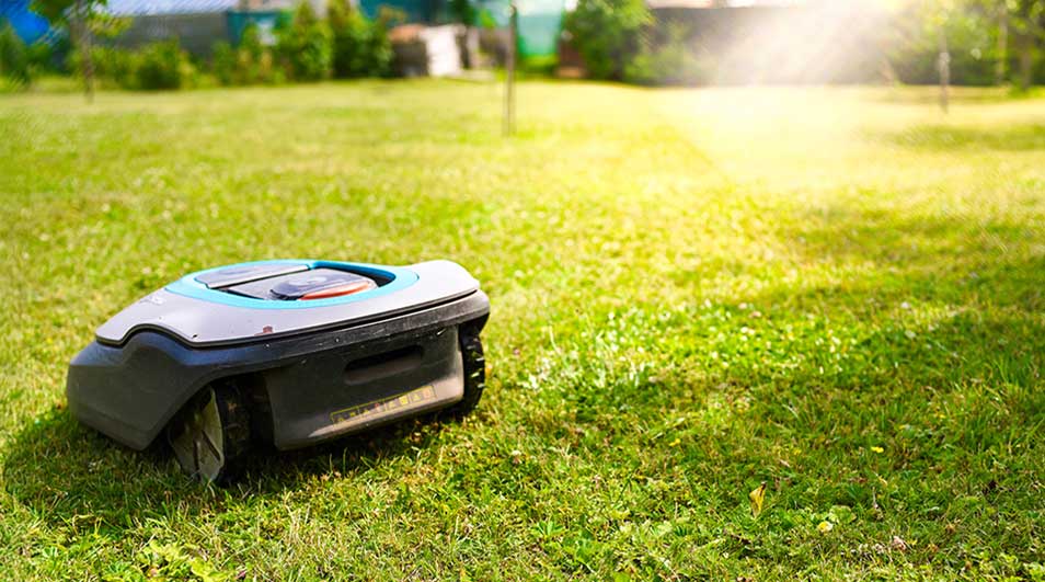 Une tondeuse robot Gardena tond automatiquement la pelouse verte sans intervention humaine.