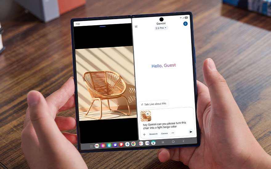 A Samsung foldable tablet is held in both hands, showing two apps side by side, including Gemini and an image of a chair.