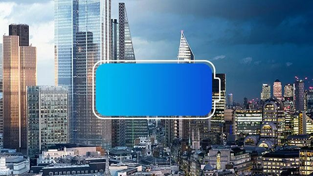 Un paysage urbain avec de grands immeubles et un indicateur de batterie bleu au centre.