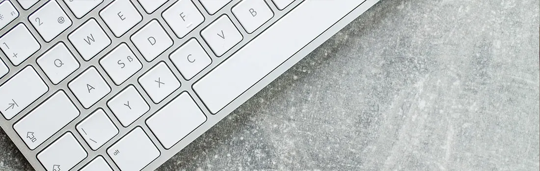 Clavier blanc sur surface grise texturée. Le clavier occupe une partie de l'image, avec des touches carrées et des lettres.
