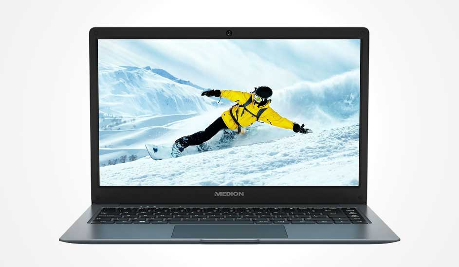 Een open MEDION laptop toont op het scherm een snowboarder in gele jas die afdaalt op een besneeuwde berg met blauwe lucht.