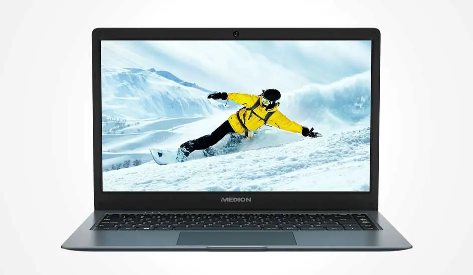 Een open MEDION laptop toont op het scherm een snowboarder in gele jas die afdaalt op een besneeuwde berg met blauwe lucht.