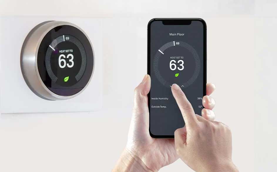 Een ronde, zilverkleurige thermostaat en een smartphone tonen beide ingestelde temperatuur van 63 graden op een witte achtergrond.