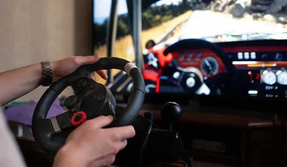 Een persoon gebruikt een zwart stuur met versnellingspook voor een tv-scherm waarop een autorace te zien is.