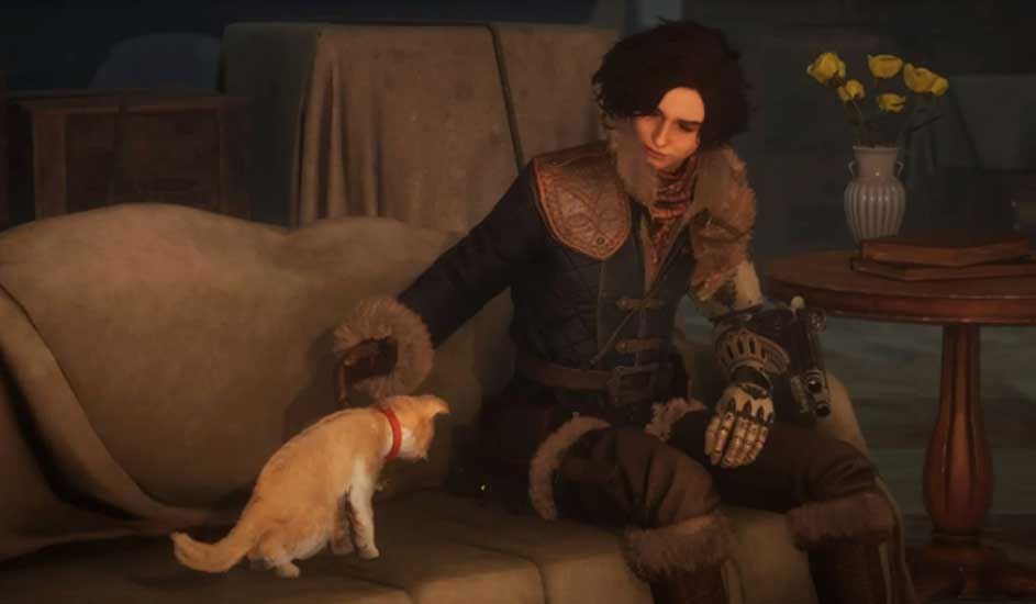 Un chat roux avec un collier rouge se tient près d'un canapé beige. Une personne est assise sur le canapé, portant un vêtement foncé.