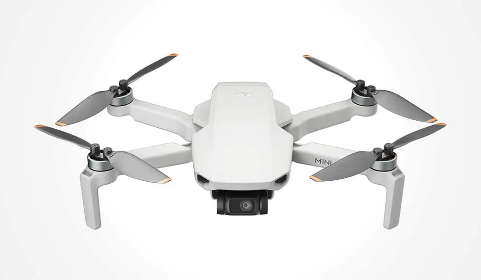 Voici un drone DJI Mini blanc avec quatre hélices et une caméra à l’avant, compact et léger.