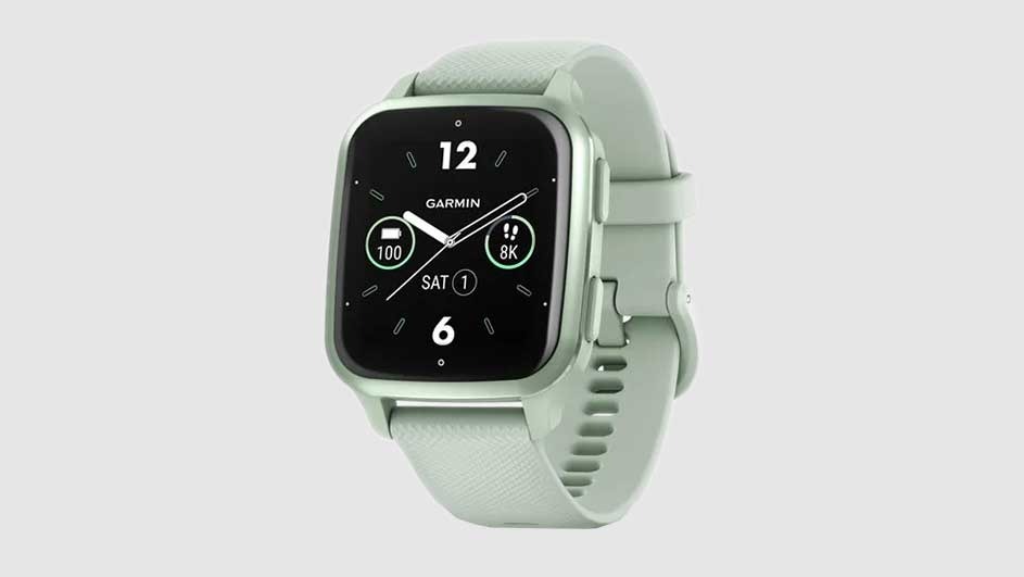 A light green Garmin smartwatch with a black screen displays the time and health metrics. The watch has a matching light green wristband.