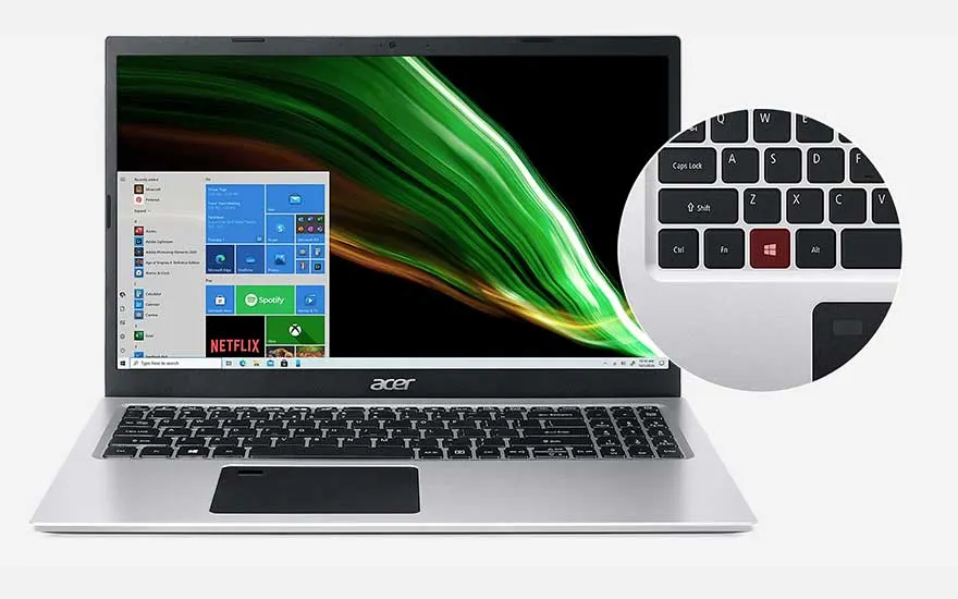 Ordinateur portable Acer gris ouvert, affichant Windows avec un fond d'écran vert et une loupe de clavier.