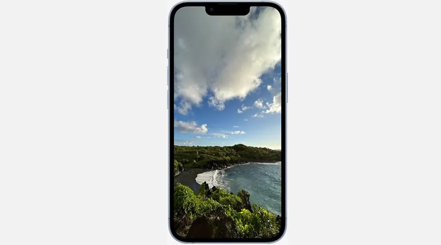 Un smartphone affiche une plage noire, une mer bleue et un ciel nuageux.