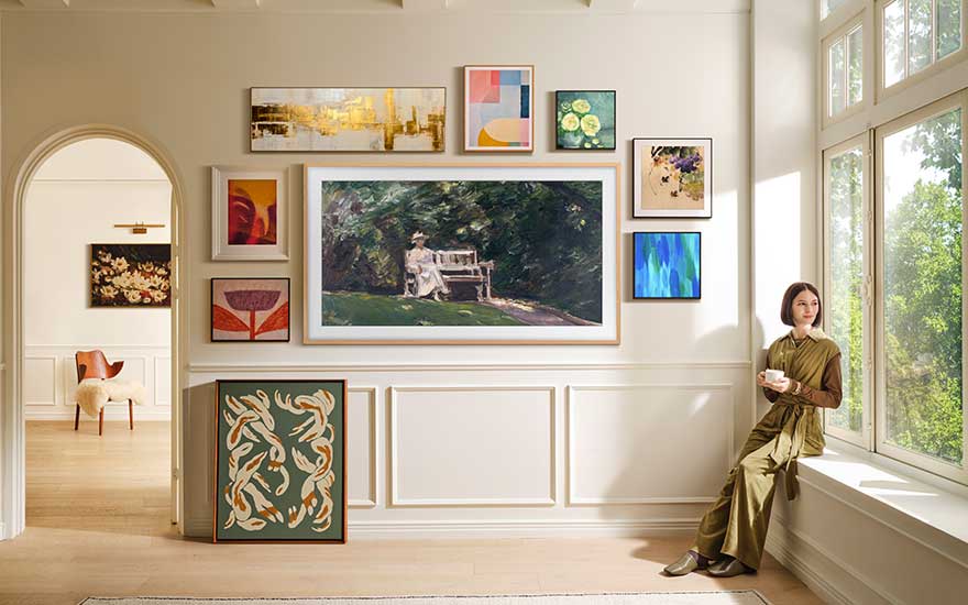 Colourful paintings and patterns are arranged around a large framed artwork on a stairway wall, in a luminous and stylish area.