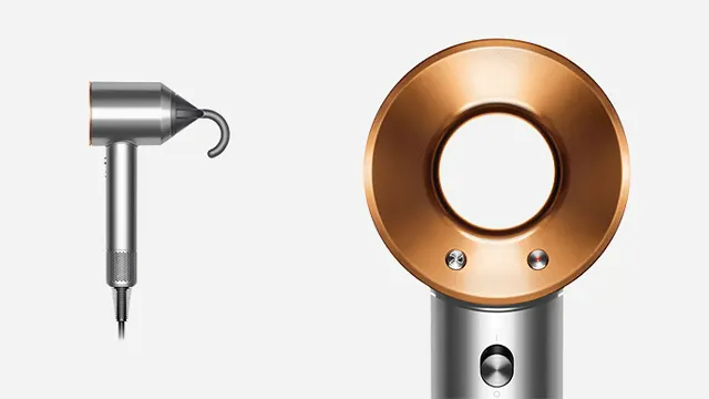 Deux appareils Dyson sur fond blanc. À gauche, un sèche-cheveux argenté avec un embout. À droite, un sèche-cheveux rond doré sur une base argentée.