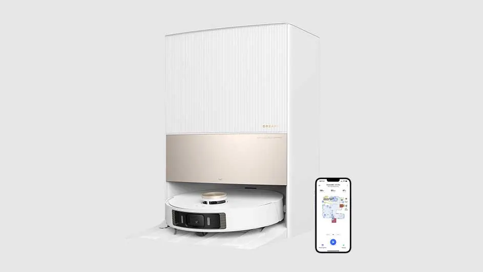 Een witte robotstofzuiger in een laadstation met een beige accent, naast een smartphone met een plattegrond.