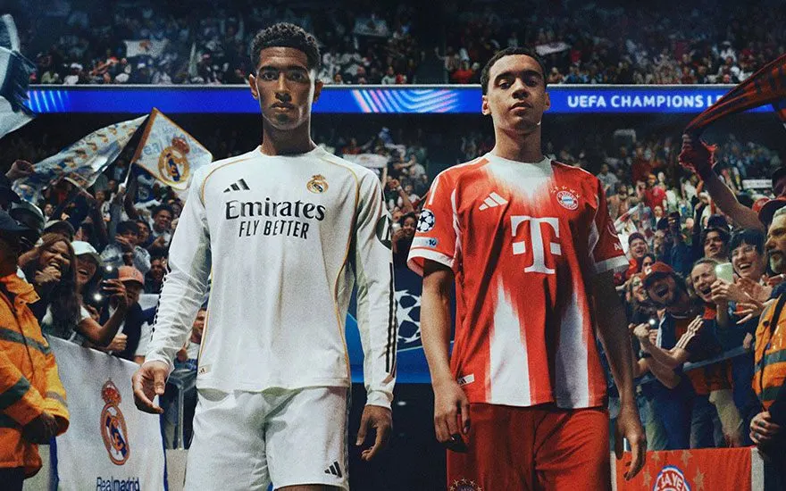Twee voetballers in Real Madrid wit shirt en Bayern München rood shirt poseren voor juichende menigte supporters